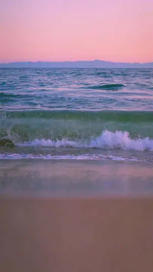 a beach with waves and a sunset